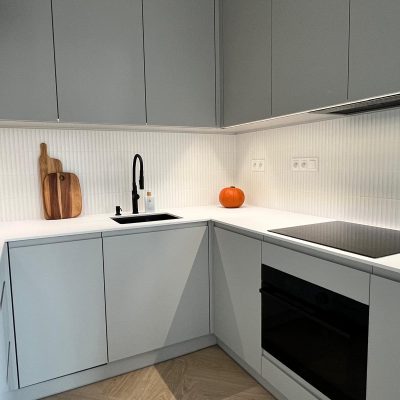 Kaszmirowe fronty lakierowane z uchwytem frezowanym i podchwytem LED tworzą lekką, nowoczesną i elegancką zabudowę kuchenną.