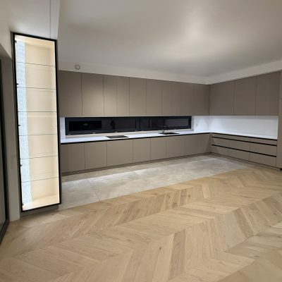 Nowoczesna kuchnia z witryną w czarnej ramie aluminiowej ZOBAL, szkłem ryflowanym i podświetlanym wnętrzem w dekorze Dąb Casella.