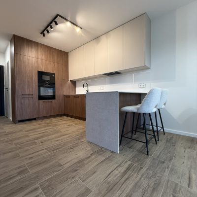 Elegancka kuchnia z blatem HPL Forner BB402, zlewem podwieszanym i płytą indukcyjną zlicowaną z powierzchnią blatu.
